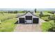 Large three-car garage with a spacious driveway and well-maintained landscaping at 1550 Ajax St, Strasburg, CO 80136