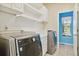 Well-lit laundry room features modern washer and dryer, storage cabinets and shelves at 1550 Ajax St, Strasburg, CO 80136