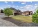 Backyard view showcasing lush lawn, mature tree, and tiered patio design with outdoor living spaces at 12939 Wabash Ct, Thornton, CO 80602