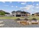 Spacious backyard featuring manicured lawn, landscaped terraces, stone firepit, and covered patio with scenic vistas at 12939 Wabash Ct, Thornton, CO 80602