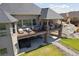 A large covered deck with outdoor seating and stairs to a hot tub below at 12939 Wabash Ct, Thornton, CO 80602