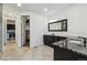 Bathroom featuring dual sinks, a spacious vanity, a large mirror, and a walk-in closet at 12939 Wabash Ct, Thornton, CO 80602