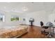 Large bedroom with three windows, hardwood floors, neutral color scheme and flexible living space at 12939 Wabash Ct, Thornton, CO 80602
