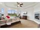 Bright bedroom with a large window offering scenic views, a ceiling fan and a cozy fireplace at 12939 Wabash Ct, Thornton, CO 80602