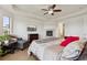 Comfortable bedroom featuring a cozy fireplace, ceiling fan, TV and seating area at 12939 Wabash Ct, Thornton, CO 80602
