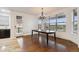 Bright dining room features hardwood floors, chandelier, and large windows with scenic golf course views at 12939 Wabash Ct, Thornton, CO 80602