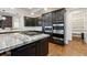 Kitchen features dark cabinets, stainless steel appliances, granite countertops, and a cooktop island at 12939 Wabash Ct, Thornton, CO 80602