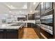 Modern kitchen with stainless steel appliances, dark wood cabinets, and a large island with granite countertops at 12939 Wabash Ct, Thornton, CO 80602