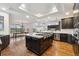 Spacious kitchen flows into dining area and features stainless steel appliances, dark cabinets, and a large center island at 12939 Wabash Ct, Thornton, CO 80602