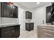 Laundry room with black cabinets, tile floors, a sink, and modern appliances at 12939 Wabash Ct, Thornton, CO 80602
