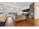 Bright living room featuring a stone fireplace, hardwood floors, and abundant natural light at 12939 Wabash Ct, Thornton, CO 80602