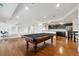 Bright living room with pool table, hardwood floors, wet bar, and built-in shelving at 12939 Wabash Ct, Thornton, CO 80602