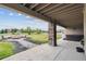 Covered patio boasts stone pillars, a cozy stone bench firepit, a relaxing hot tub, and scenic backyard views at 12939 Wabash Ct, Thornton, CO 80602