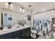 Bathroom featuring double vanity, modern fixtures and a shower with a forest-themed curtain at 2419 Flats St, Erie, CO 80516