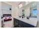 Bathroom with dual sinks, black fixtures and a mirror with views to the Primary bedroom at 2419 Flats St, Erie, CO 80516