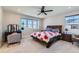 Inviting bedroom featuring a wooden bed frame, bright windows and a ceiling fan at 2419 Flats St, Erie, CO 80516