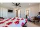 Comfortable bedroom with ceiling fan and floral bedding, complemented by a window view at 2419 Flats St, Erie, CO 80516