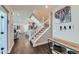 Welcoming entryway featuring hardwood floors, a staircase, and modern decor at 2419 Flats St, Erie, CO 80516