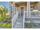 Inviting front porch with white railing and steps, complemented by vibrant landscaping and a modern door at 2419 Flats St, Erie, CO 80516