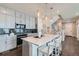 Bright kitchen with white cabinetry, an island with seating, and stainless steel appliances at 2419 Flats St, Erie, CO 80516