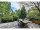 Backyard deck featuring an outdoor dining area, surrounded by a lush landscape of trees and plants at 5320 S Geneva St, Englewood, CO 80111