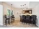 Basement bar area with dark wood cabinets, granite counters, and pendant lighting at 5320 S Geneva St, Englewood, CO 80111