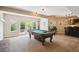 Finished basement with pool table, bar area, and access to outdoor patio with fire pit at 5320 S Geneva St, Englewood, CO 80111