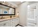 Well-lit bathroom with dual sinks, granite countertop, and a separate shower and tub at 5320 S Geneva St, Englewood, CO 80111