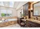 Luxurious bathroom featuring a soaking tub, dual vanities, and a skylight, providing a spa-like experience at 5320 S Geneva St, Englewood, CO 80111