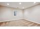 A carpeted bedroom with beige walls and a small window that provides natural light at 5320 S Geneva St, Englewood, CO 80111