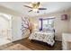 Bright bedroom features a bed with floral bedding, hardwood floors, ceiling fan and lots of natural light at 5320 S Geneva St, Englewood, CO 80111