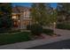 A well-maintained two-story home with a brick facade, manicured landscaping, and a driveway leading to a garage at 5320 S Geneva St, Englewood, CO 80111