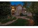 A charming two-story home with a brick facade and lush landscaping around the front entrance and driveway at 5320 S Geneva St, Englewood, CO 80111