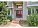 Charming home featuring a brick entryway and a vibrant red front door at 5320 S Geneva St, Englewood, CO 80111