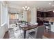 Bright dining area features a modern chandelier, sliding glass doors, and flows into the open kitchen at 15350 W 50Th Dr, Golden, CO 80403