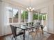 Bright dining area features a modern chandelier, large windows, and flows into the open kitchen at 15350 W 50Th Dr, Golden, CO 80403