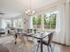 Bright dining room features modern light fixture, large windows, and seating for six, with an adjacent living room at 15350 W 50Th Dr, Golden, CO 80403