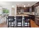 Open kitchen features a large island with bar seating, stainless steel appliances, and dark cabinetry at 15350 W 50Th Dr, Golden, CO 80403