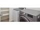 Efficient laundry room with modern washer and dryer, plus shelving for storage and easy organization at 15350 W 50Th Dr, Golden, CO 80403