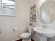 Cozy powder room with a pedestal sink and framed artwork at 15350 W 50Th Dr, Golden, CO 80403