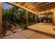A backyard at dusk featuring a lighted pergola, a patio, and professional landscaping at 2746 Stallion Way, Mead, CO 80542