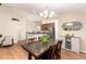 Open dining room featuring hardwood floors, chandelier, and bright natural light from a large window at 2746 Stallion Way, Mead, CO 80542