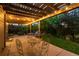 Cozy covered patio with bistro set and string lights overlooking the lush backyard at 2746 Stallion Way, Mead, CO 80542