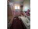 Pink and black tiled bathroom with tub and single sink at 6552 S Pearl St, Centennial, CO 80121