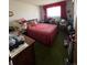 Functional bedroom with a red patterned bedspread and limited natural light at 6552 S Pearl St, Centennial, CO 80121