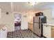 Open basement kitchen showcasing a stainless steel refrigerator, a microwave, and laminate counters at 4001 Kalamath St, Denver, CO 80211