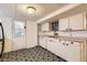 Efficient basement kitchen with white cabinets, laminate counters, and decorative door at 4001 Kalamath St, Denver, CO 80211