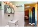 Charming bathroom with unique mirror fixture, white tile, and colorful entry at 4001 Kalamath St, Denver, CO 80211