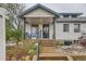 Charming home featuring a covered front porch with seating and stone accents at 4001 Kalamath St, Denver, CO 80211