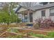 Charming home exterior showcasing the covered porch and landscaped front yard at 4001 Kalamath St, Denver, CO 80211